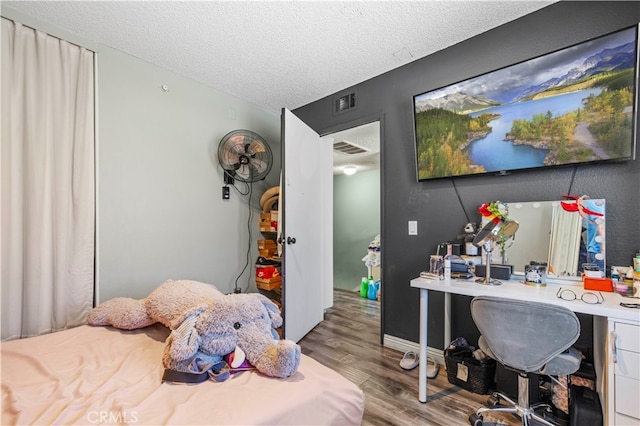 bedroom with wood-type flooring and a textured ceiling