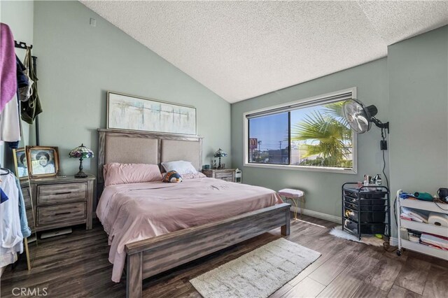 bedroom featuring dark hardwood / wood-style flooring, a textured ceiling, and vaulted ceiling