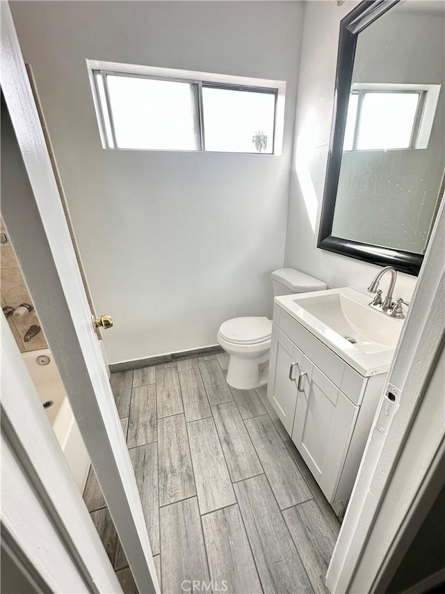 bathroom with wood tiled floor, vanity, and toilet