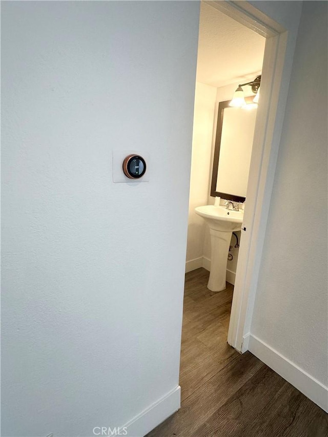 bathroom with a sink, baseboards, and wood finished floors