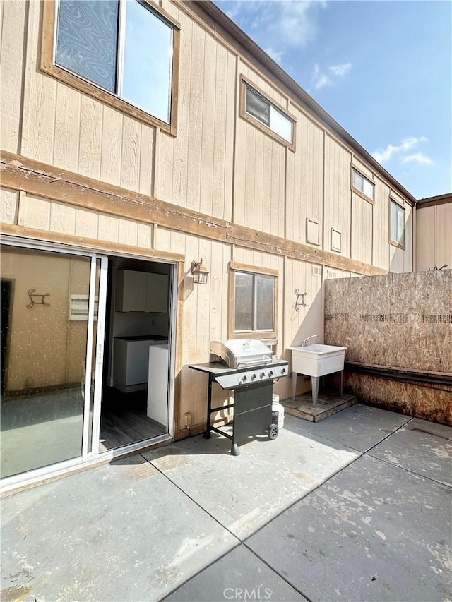 back of property featuring a patio area and a sink