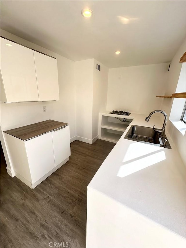 kitchen featuring visible vents, dark wood-style floors, white cabinetry, a sink, and recessed lighting