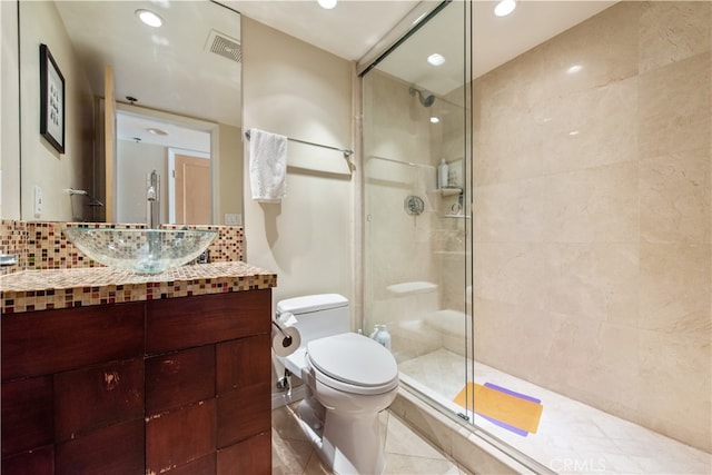 bathroom featuring vanity, tile patterned flooring, backsplash, a shower with shower door, and toilet