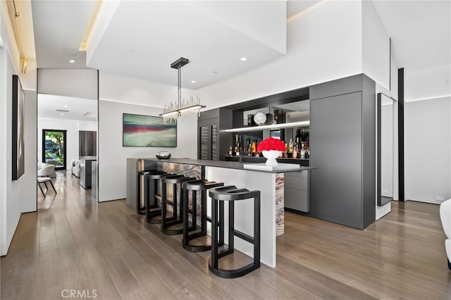 kitchen with pendant lighting, dark wood-type flooring, a breakfast bar area, and a high ceiling