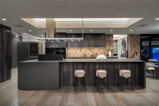 kitchen with a breakfast bar area, decorative backsplash, and a spacious island