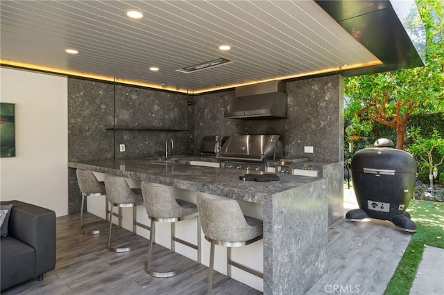 exterior space featuring a grill, an outdoor wet bar, and exterior kitchen