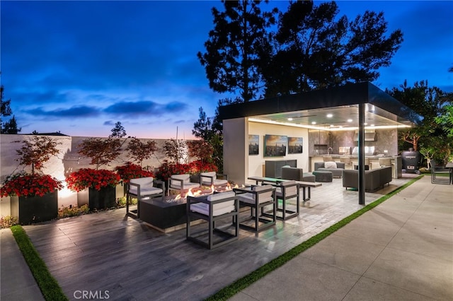 patio terrace at dusk featuring area for grilling and an outdoor hangout area