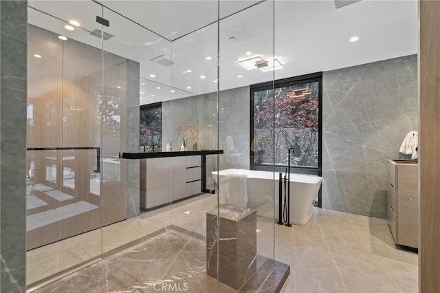 bathroom featuring a washtub and tile walls