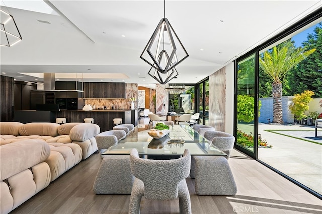 dining area featuring floor to ceiling windows, wood-type flooring, and an inviting chandelier