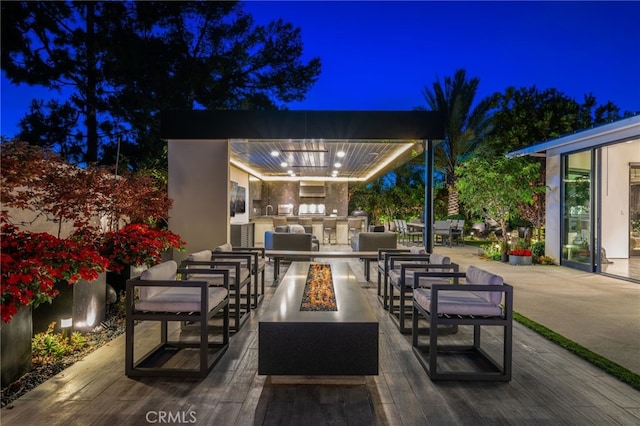 patio at night featuring a fire pit and area for grilling