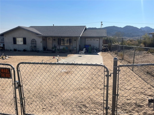 single story home featuring a mountain view, a patio, and a garage