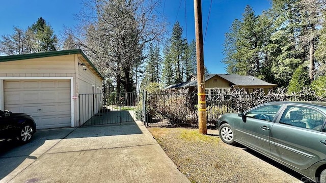 view of side of home featuring a garage and an outbuilding