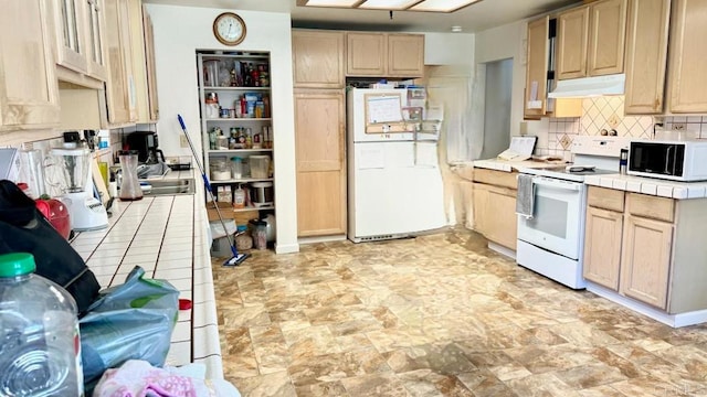 kitchen featuring tile countertops, light brown cabinets, white appliances, and tasteful backsplash