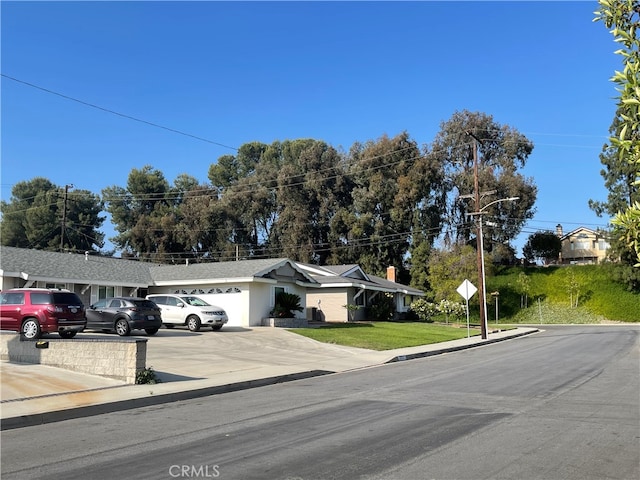 ranch-style home with a front lawn and a garage