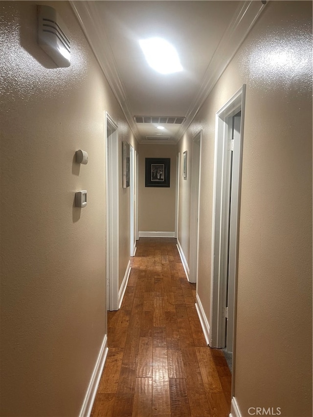 hallway featuring ornamental molding and dark hardwood / wood-style flooring