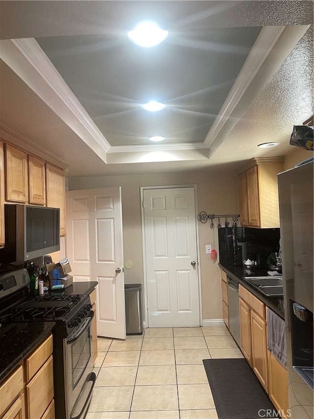 kitchen with ornamental molding, appliances with stainless steel finishes, light tile patterned floors, and a raised ceiling