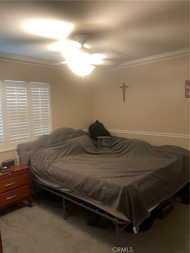 carpeted bedroom featuring ornamental molding and ceiling fan