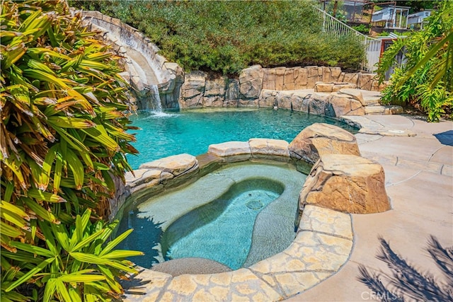 view of pool featuring an in ground hot tub and pool water feature