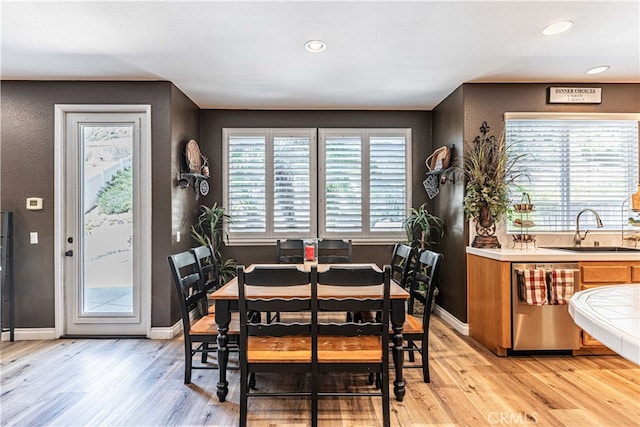 dining area with sink and light hardwood / wood-style floors