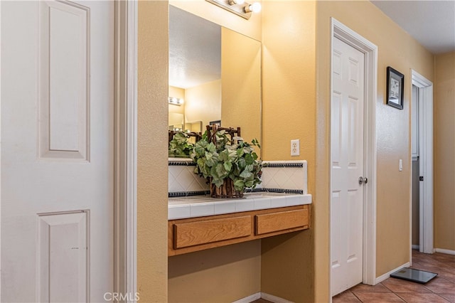 bathroom featuring vanity, backsplash, a textured ceiling, and tile patterned floors