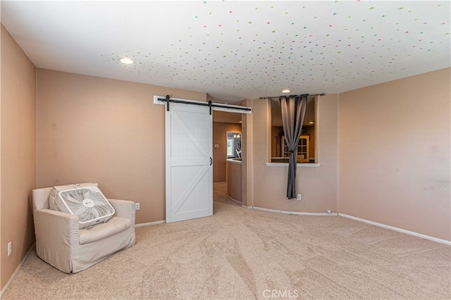 unfurnished room featuring carpet flooring and a barn door