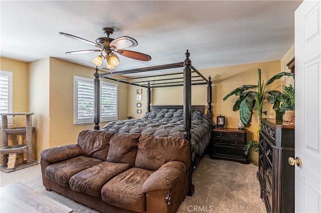 bedroom with ceiling fan, a textured ceiling, carpet flooring, and multiple windows