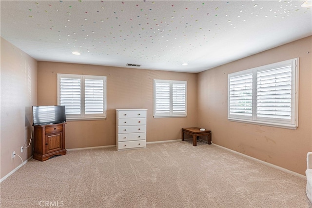 unfurnished bedroom with multiple windows and light carpet