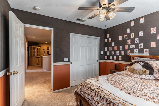 carpeted bedroom with ceiling fan and a closet