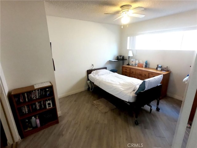 bedroom featuring wood-type flooring, a textured ceiling, and ceiling fan