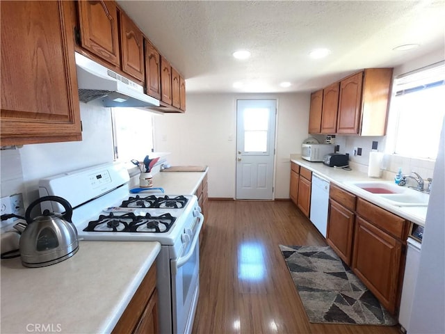 kitchen featuring a textured ceiling, white appliances, sink, and dark wood-type flooring