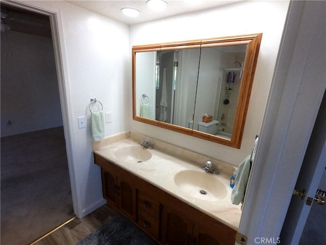 bathroom featuring hardwood / wood-style floors, vanity, and  shower combination