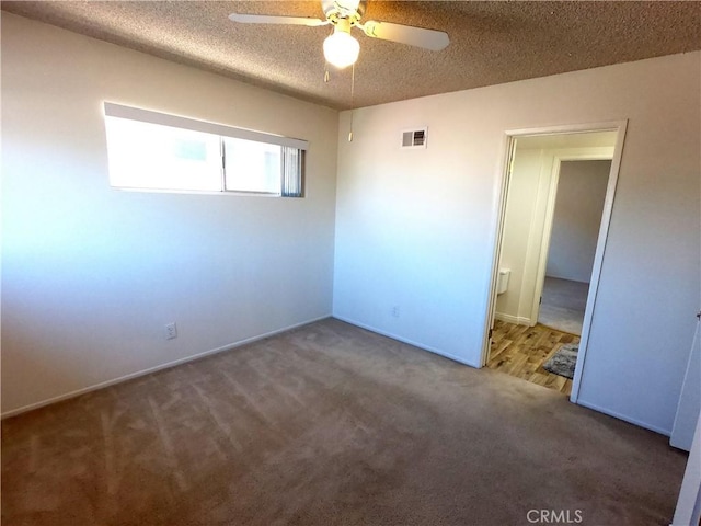 unfurnished bedroom featuring carpet flooring, ceiling fan, and a textured ceiling