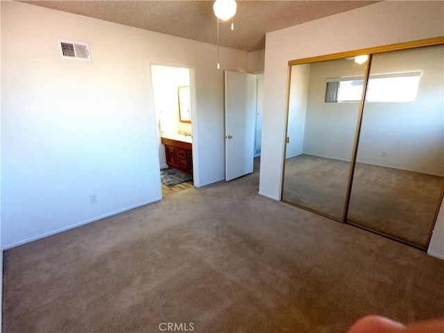 unfurnished bedroom featuring carpet, connected bathroom, and a closet