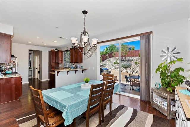 dining room with a notable chandelier and dark hardwood / wood-style floors