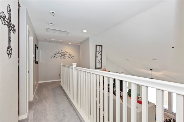 hallway featuring vaulted ceiling and light carpet