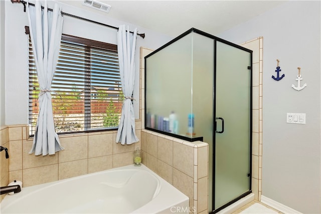 bathroom featuring shower with separate bathtub