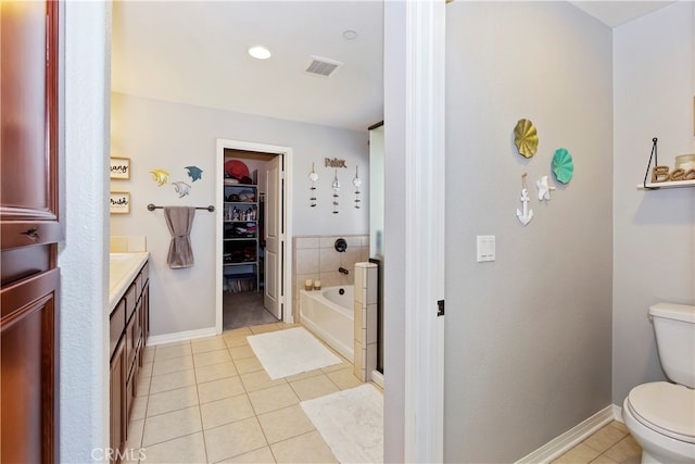 bathroom featuring vanity, toilet, tile patterned flooring, and a bathing tub