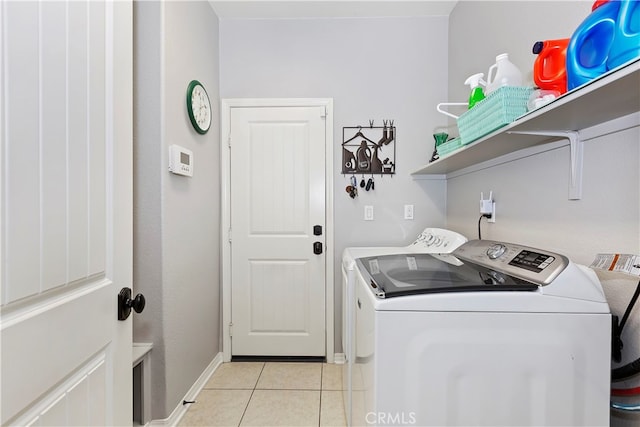 laundry area with light tile patterned floors and washer and clothes dryer