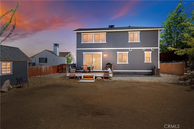 back house at dusk featuring a patio