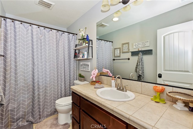 bathroom featuring toilet, vanity, a shower with shower curtain, and tile patterned flooring