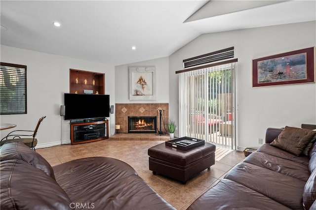 living room with a tile fireplace, light tile patterned flooring, and vaulted ceiling