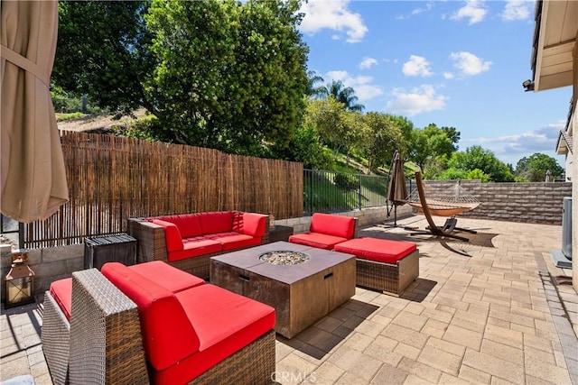 view of patio with an outdoor living space with a fire pit