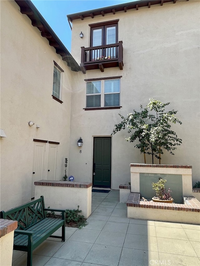 entrance to property featuring a balcony and a patio area