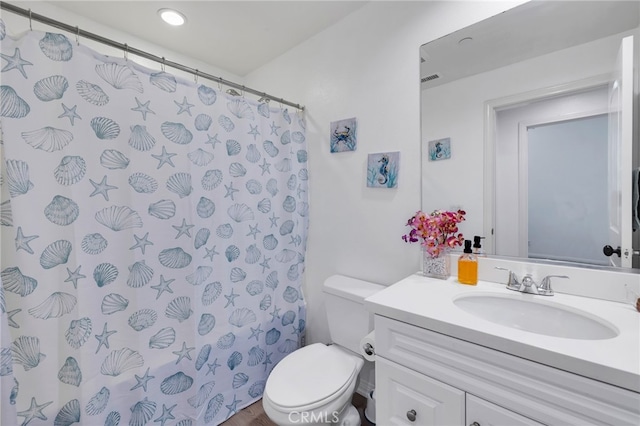 bathroom with a shower with curtain, vanity, and toilet