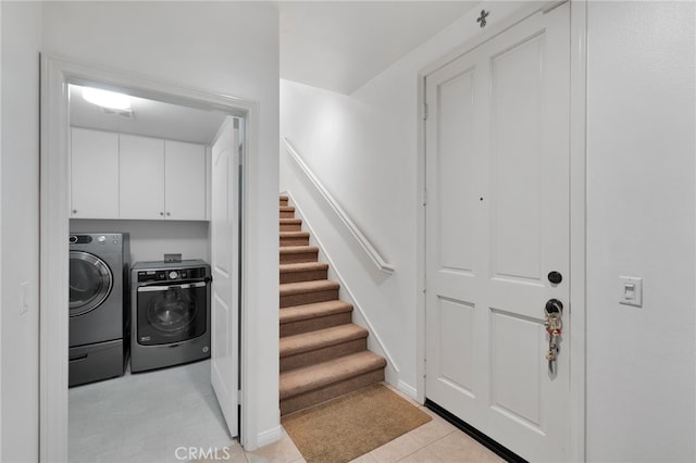 washroom with cabinets, light tile patterned flooring, and washer and dryer