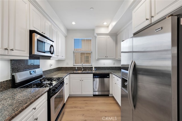 kitchen featuring stainless steel appliances, white cabinets, light hardwood / wood-style floors, and sink