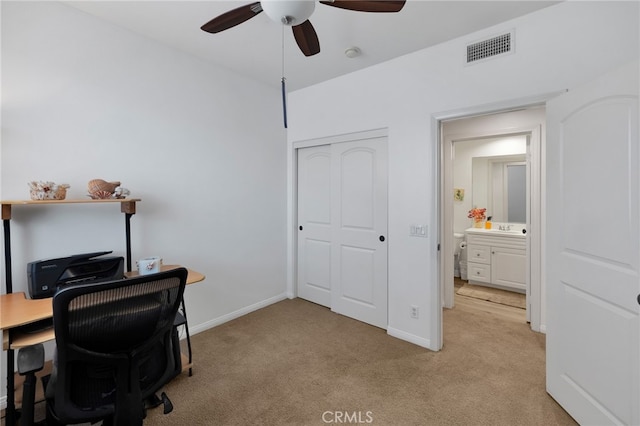 office space with ceiling fan, light carpet, and sink