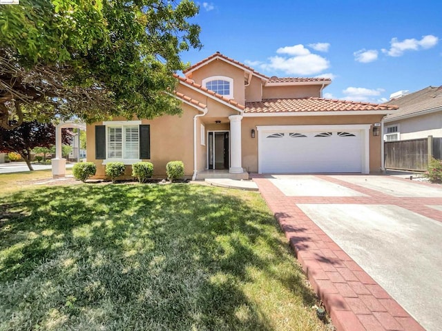 mediterranean / spanish home with a garage and a front lawn