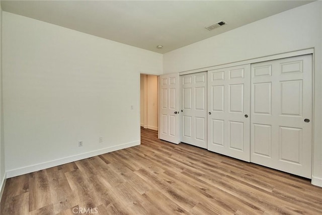 unfurnished bedroom featuring a closet and light wood-type flooring