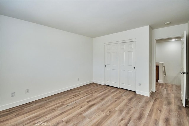 unfurnished bedroom featuring light hardwood / wood-style floors and a closet